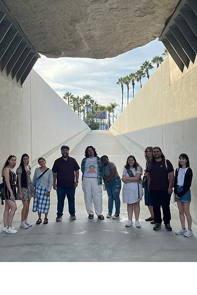 Prof. Rivas and graduate students underneath Levitated Mass, a large outdoor artwork installed at the Los Angeles County Museum of Art (LACMA)