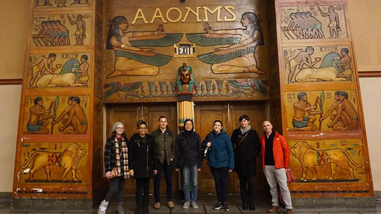 students in front of a mural wall 