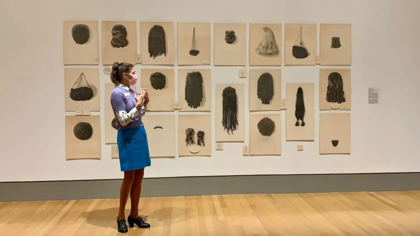 Figure standing in front of gallery wall