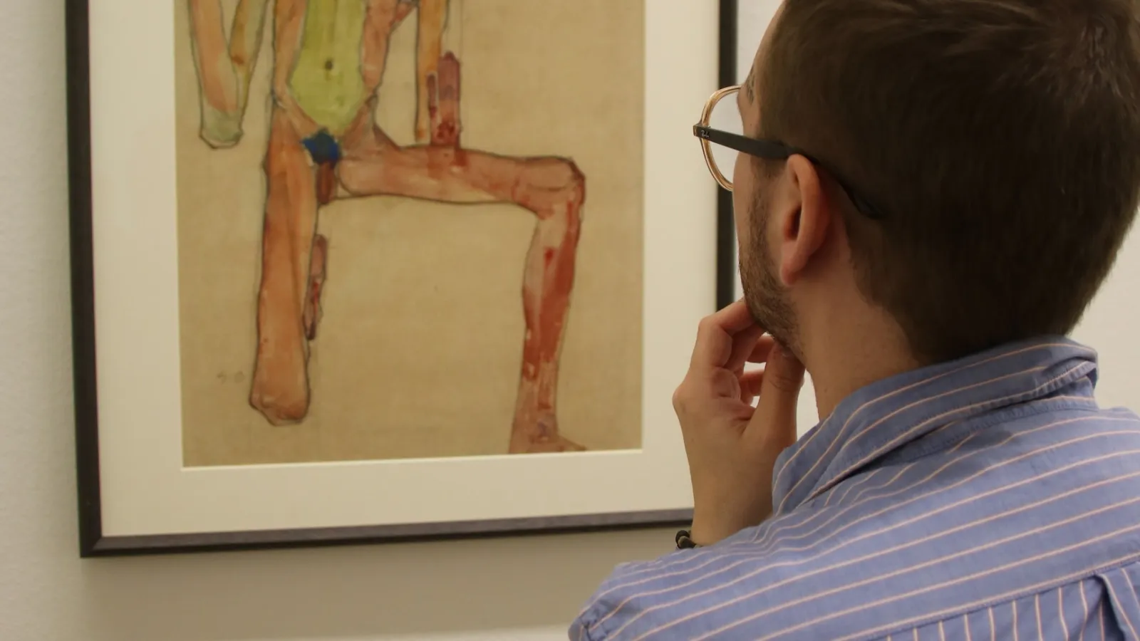 Cole Graham viewing a framed drawing by Egon Schiele