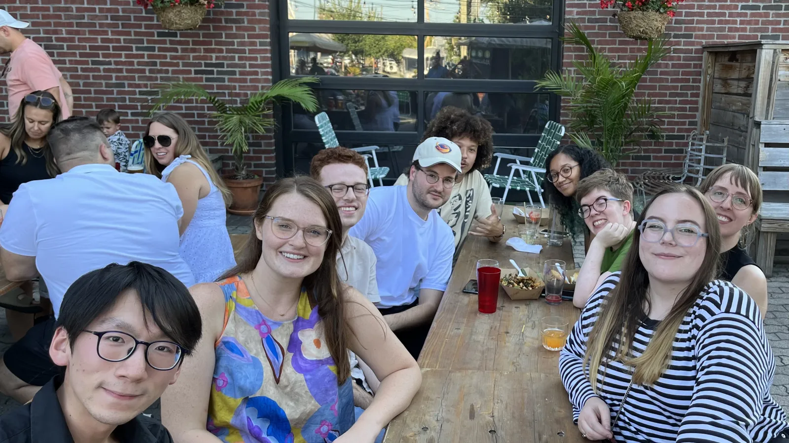 group of graduate students at social even around wooden table