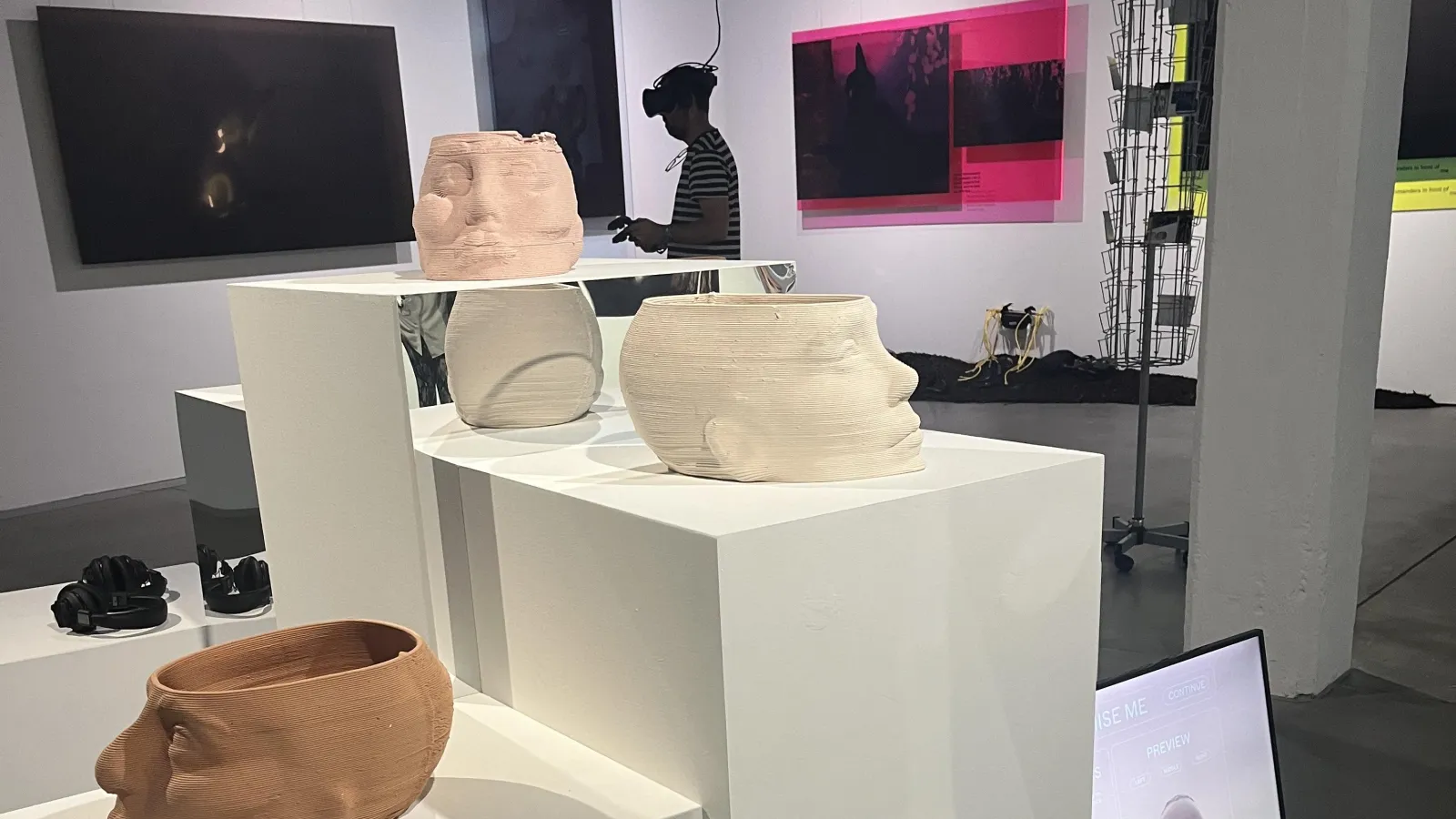 A museum display of ceramic heads on pedestals