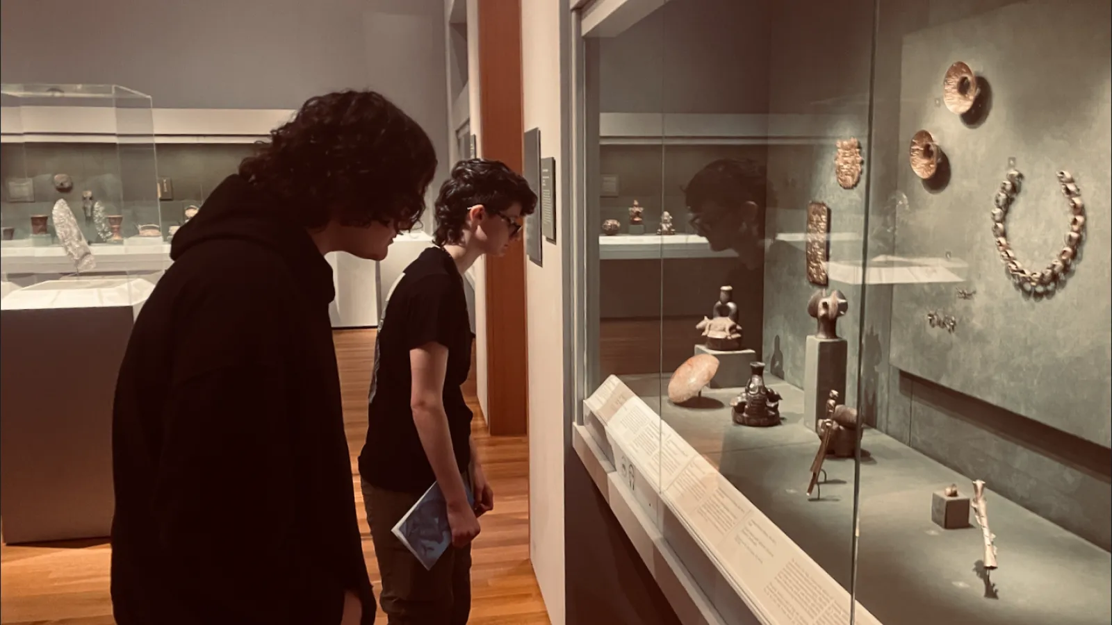 students closely viewing ancient Andean material in the Ancient Americas galleries at the Cleveland Museum of Art.   