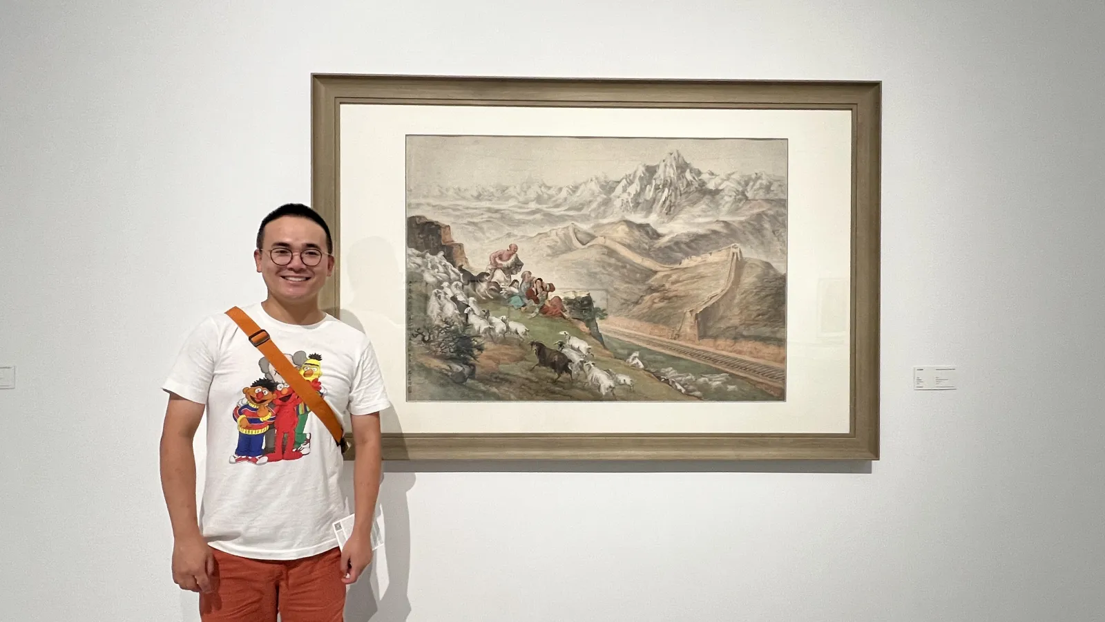 Yifan standing in front of an art piece on a wall