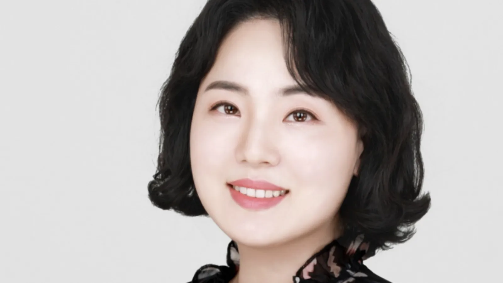 Alumni Mina Kim wearing a black blouse in front of a white background