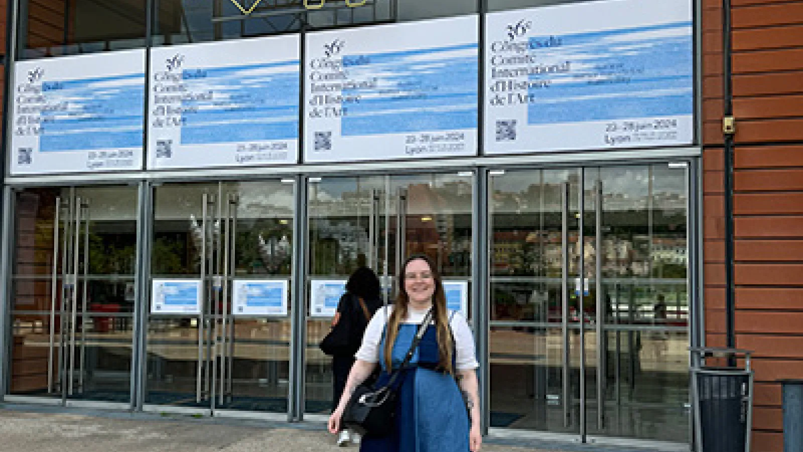 Graduate student April Riddle stands in front of the Centre de Congrès de Lyon