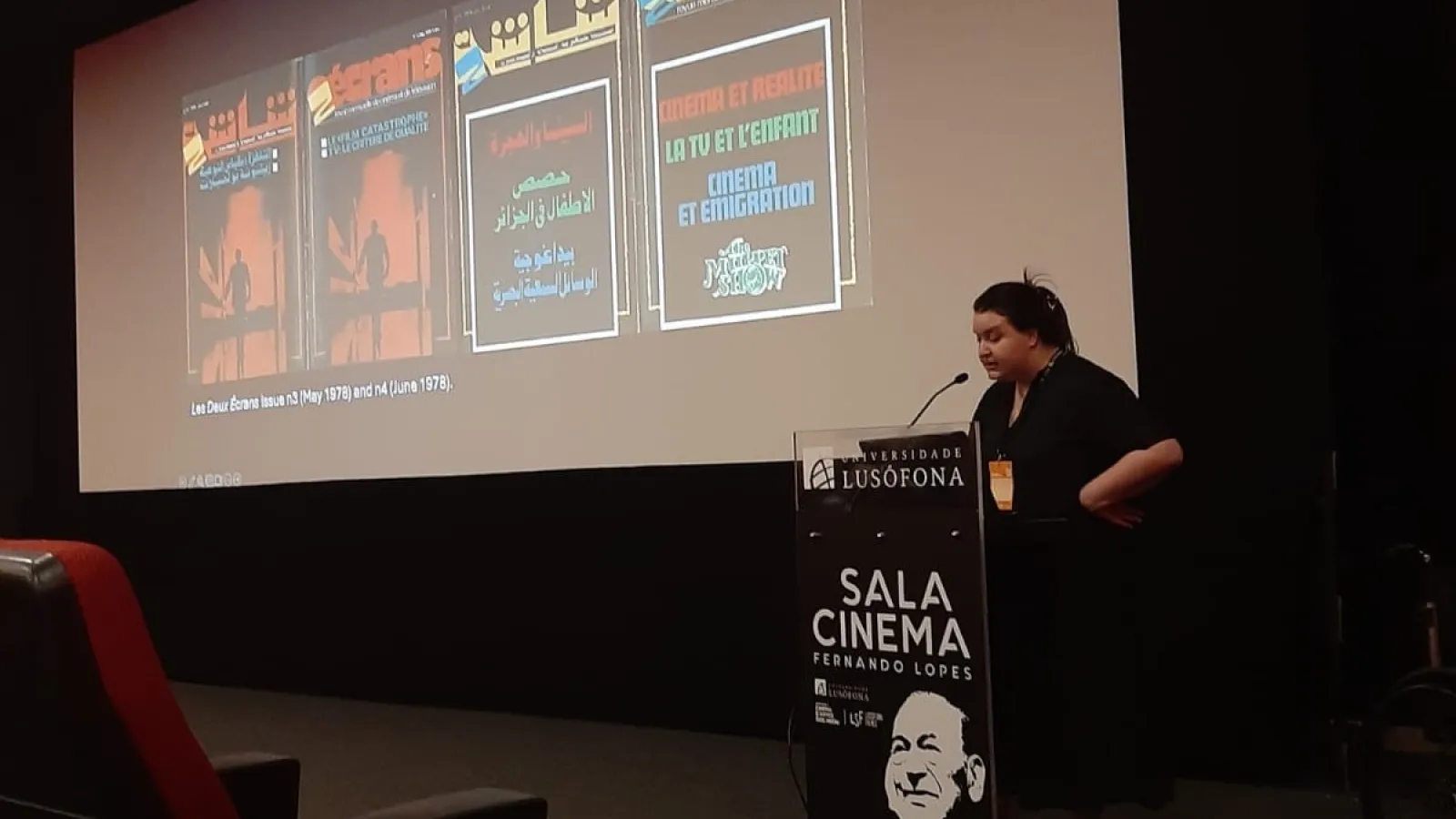 Dareen at a podium in front of a presentation