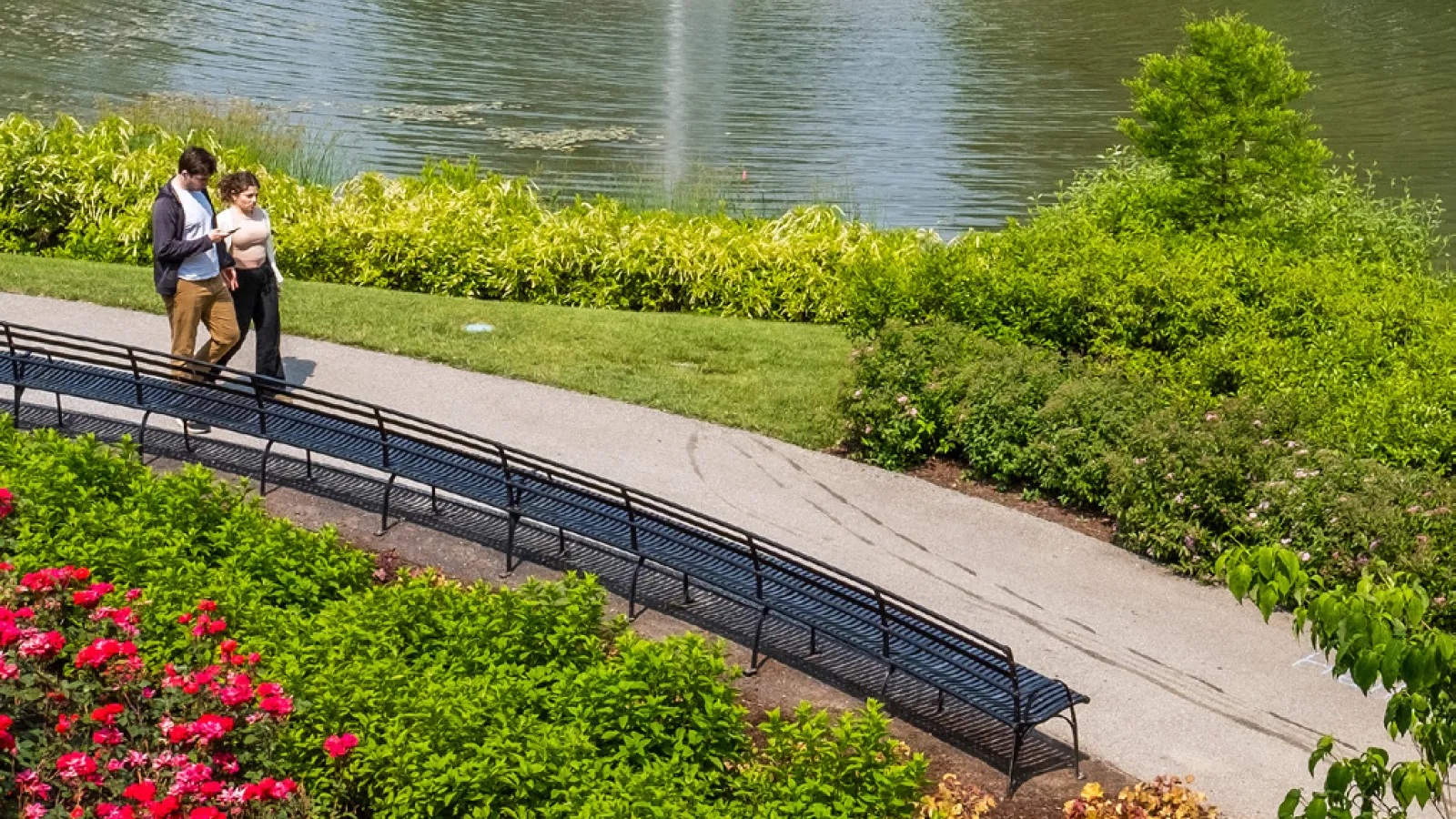 A man and woman walk alongside Mirror Lake.
