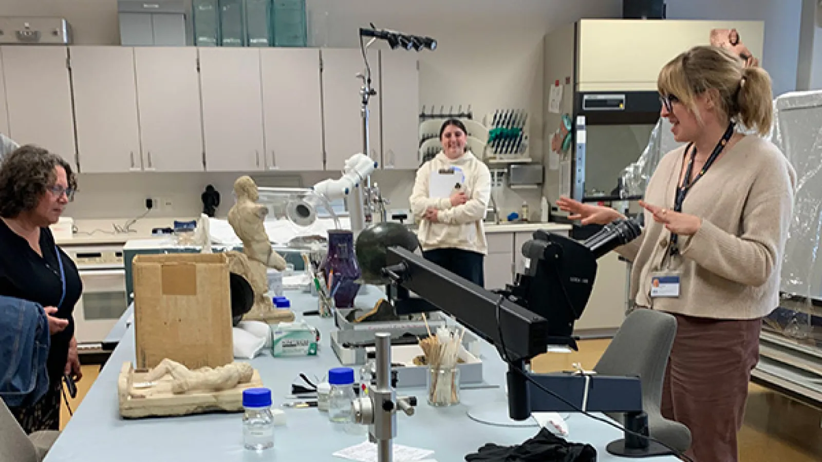 students stand around conservation lab table