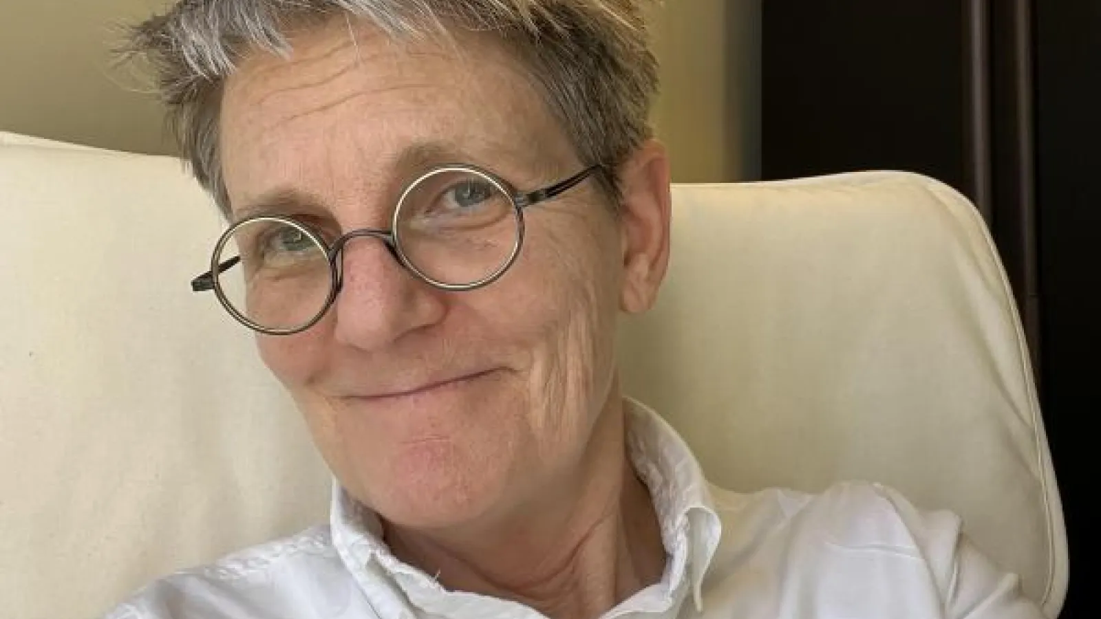 Woman in a white shirt and glasses.