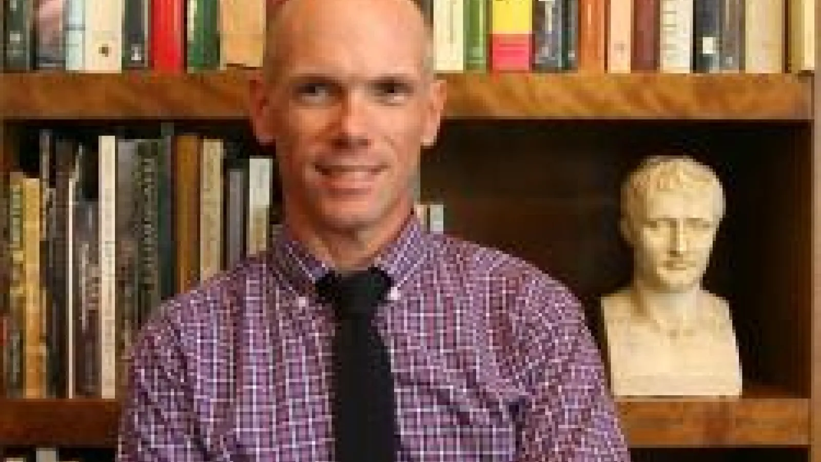 Andrew Shelton in front of a bookshelf