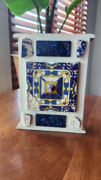 Mixed media artwork made from painted white box with blue squares. 