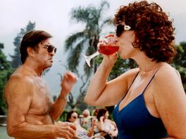 Two people drinking cocktails in bathing suits