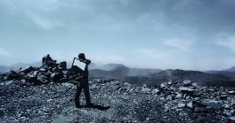 A man holding a mirror on a mountain top