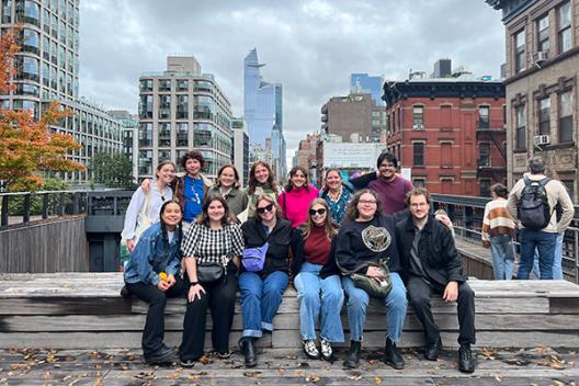 History of Art majors pose together in front of an urban landscape in New York