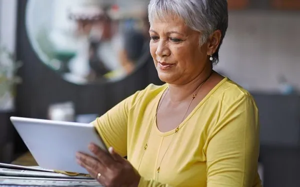Woman holding and looking at a tablet