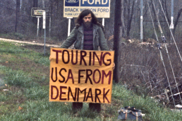 picture of a person holding a sign saying "touring USA from Denmark"
