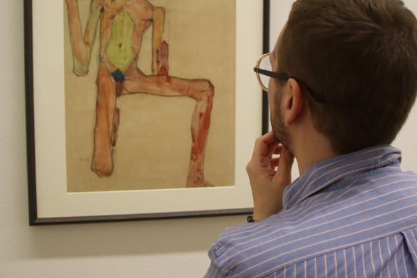 Cole Graham viewing a framed drawing by Egon Schiele