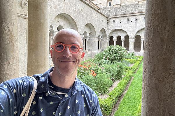Professor Karl Whittington standing in front of a medieval courtyard