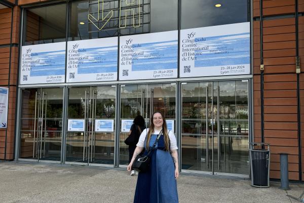 April Riddle standing outside the entrance to the 36th World Congress in Lyon, France
