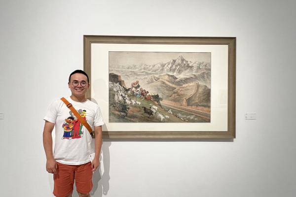 Yifan standing in front of an art piece on a wall
