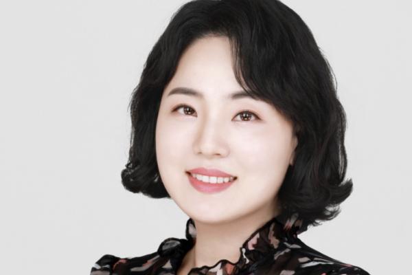 Alumni Mina Kim wearing a black blouse in front of a white background