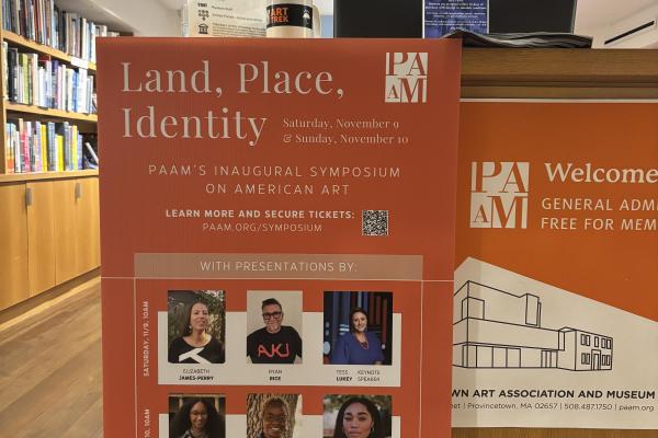 Orange PAAM symposium flyer hanging in a library