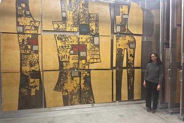 Asia Adomanis in front of artwork. 