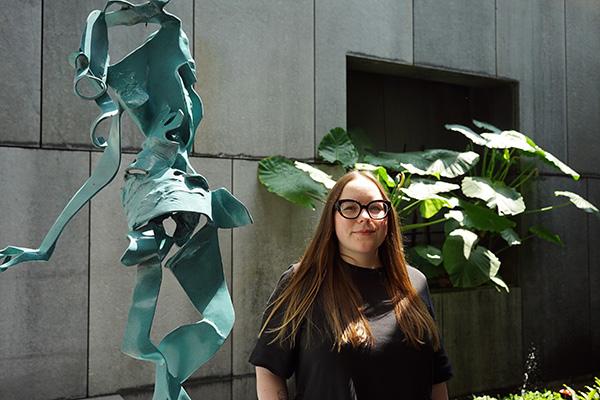 PhD candidate April Riddle stands next to one of Lee Kuang-Yu's sculptures at Asia Society Hong Kong Center
