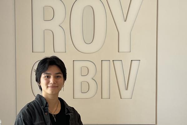 Delia Miklowski standing by ROY G BIV sign