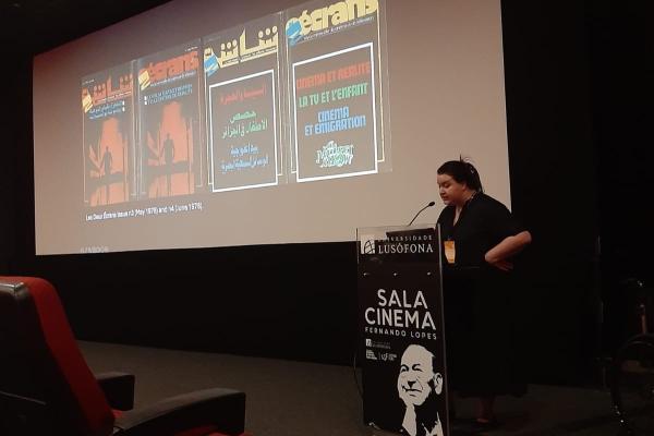 Dareen at a podium in front of a presentation