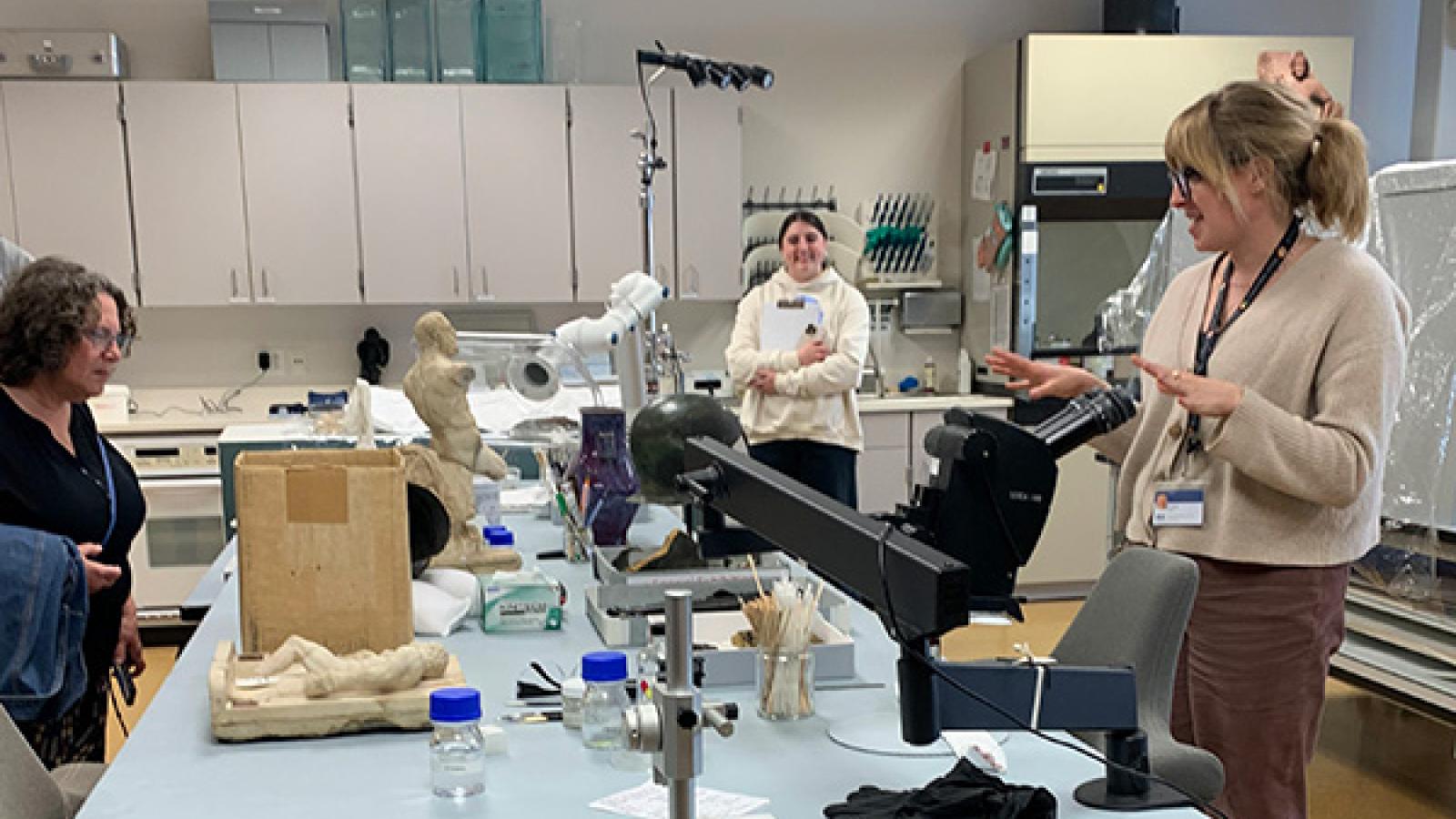 students stand around conservation lab table