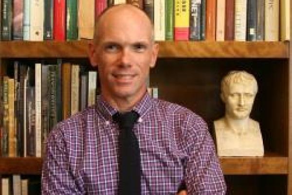 Andrew Shelton in front of a bookshelf