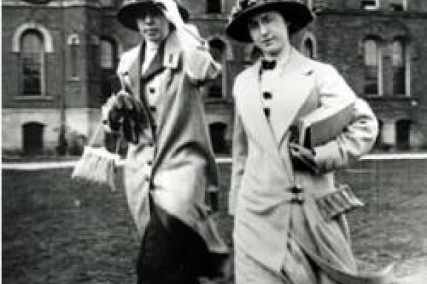 2 women walking next to each other in black and white