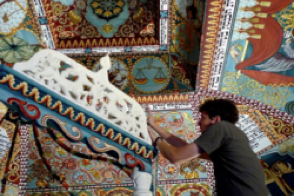 man tinkering with a sculpture