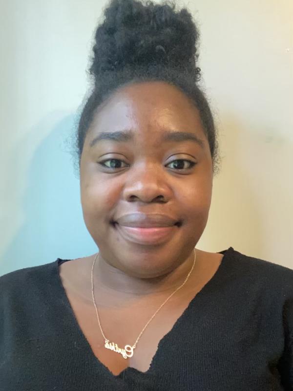 Cynthia Hodge- Thorne wearing a black top behind a white wall