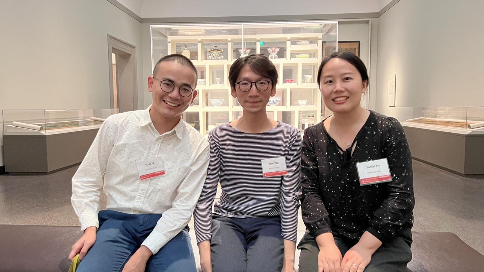 Image of  graduate students Yifan Li and Keyu Yan and PhD Alumna Effie Yin sitting and posing inside of the National Museum of Asian Art.