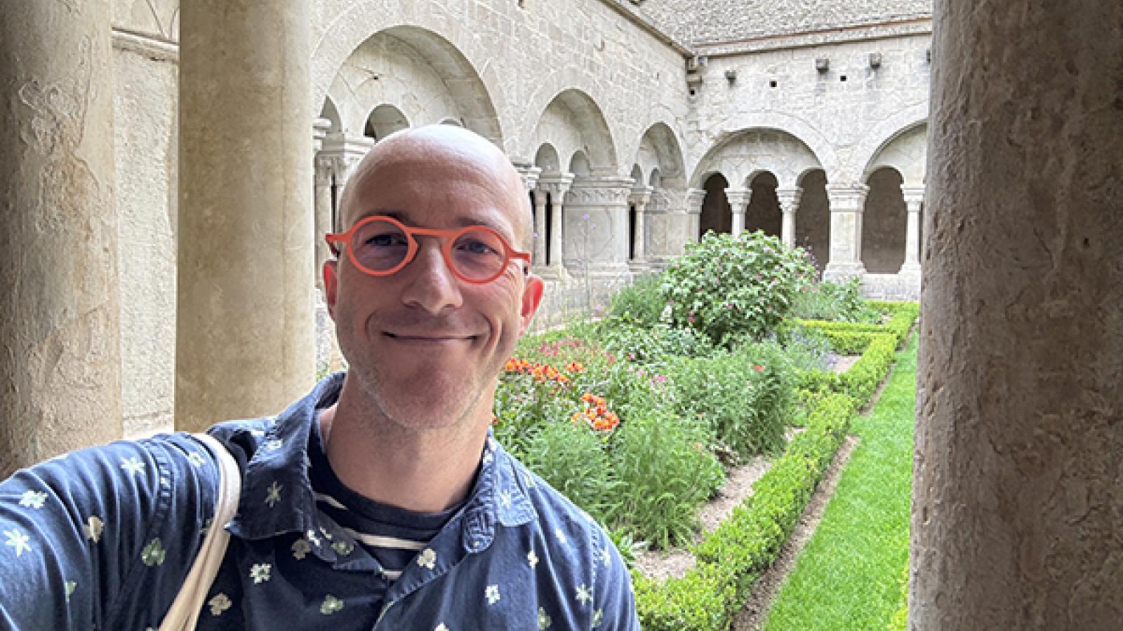Professor Karl Whittington standing in front of a medieval courtyard