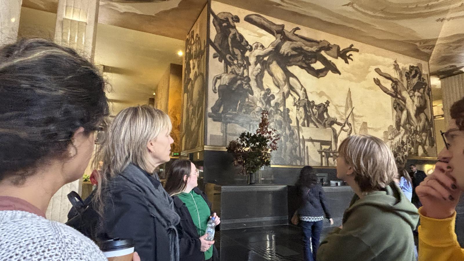 Dr. Jodie Patterson observing an art piece with two students in the Museum of Modern Art