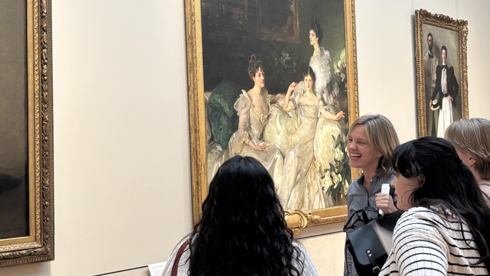 Dr. Jodie Patterson observing an art piece with two students in the Museum of Modern Art