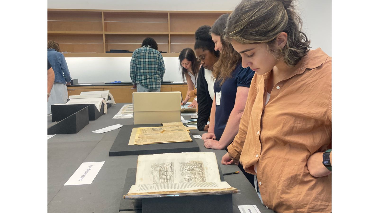 People looking at books and artifacts