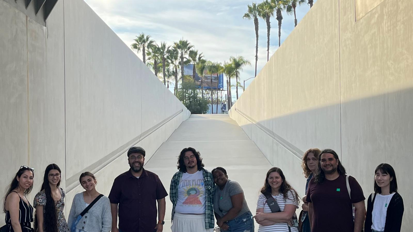 Group of people standing under a structure in the shade