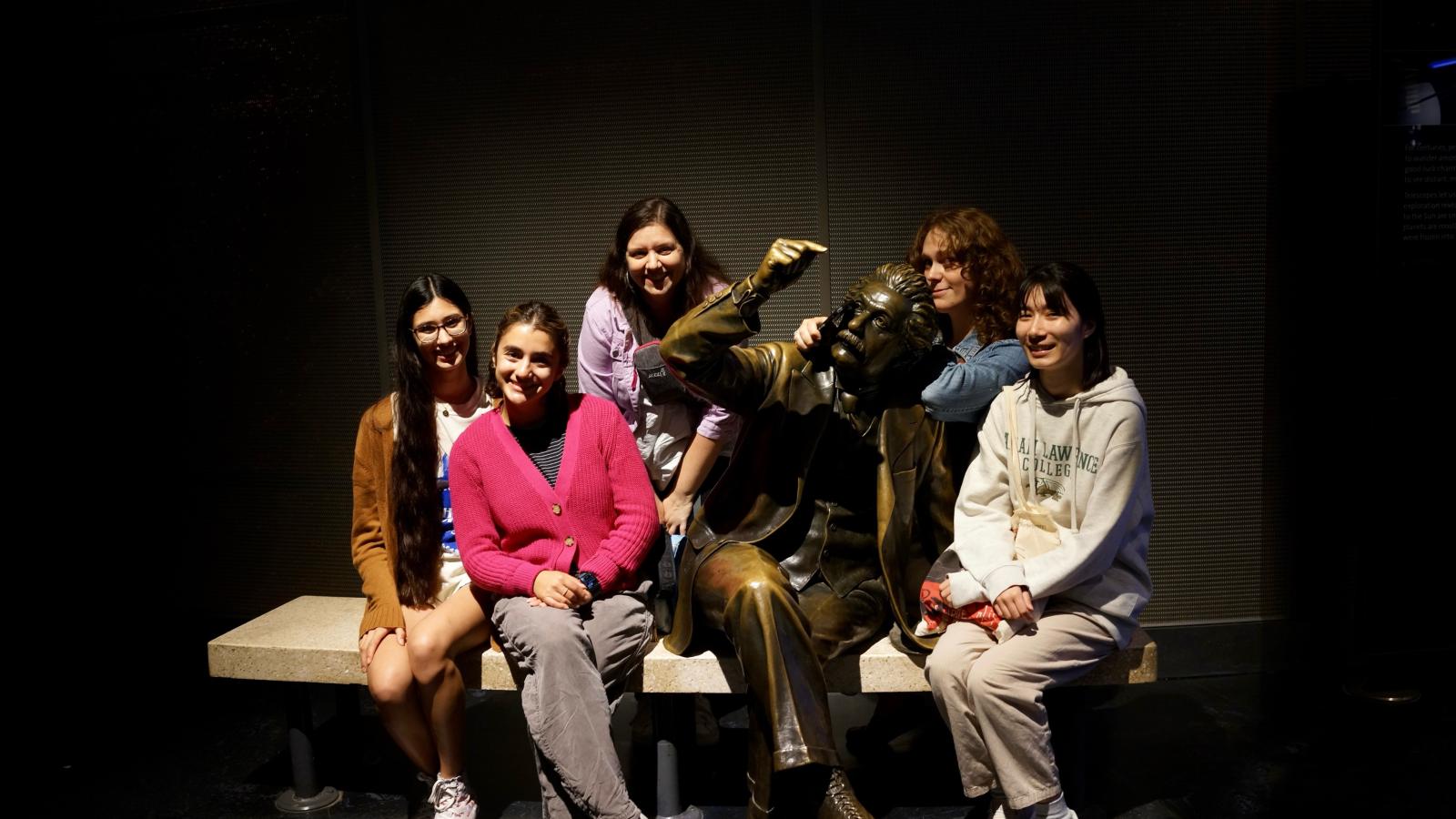 People sitting around a statue of a person