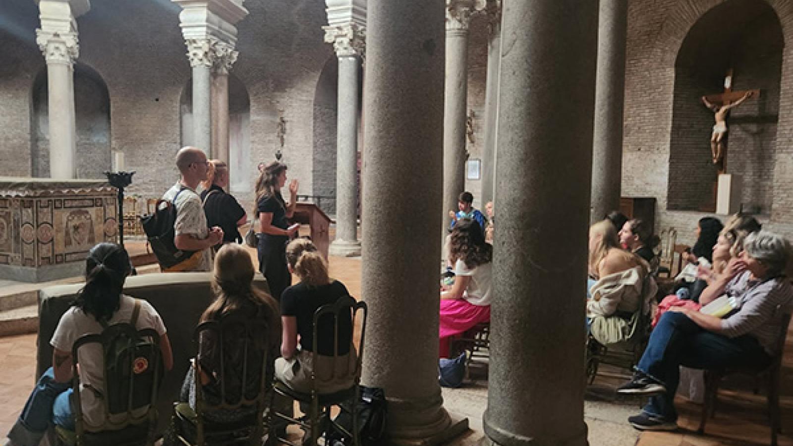 Professor Whittington and students gather inside a column-lined courtyard