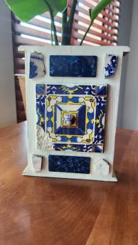 Mixed media artwork made from painted white box with blue squares. 